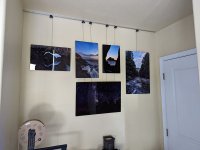 Several printed images hang on a wall